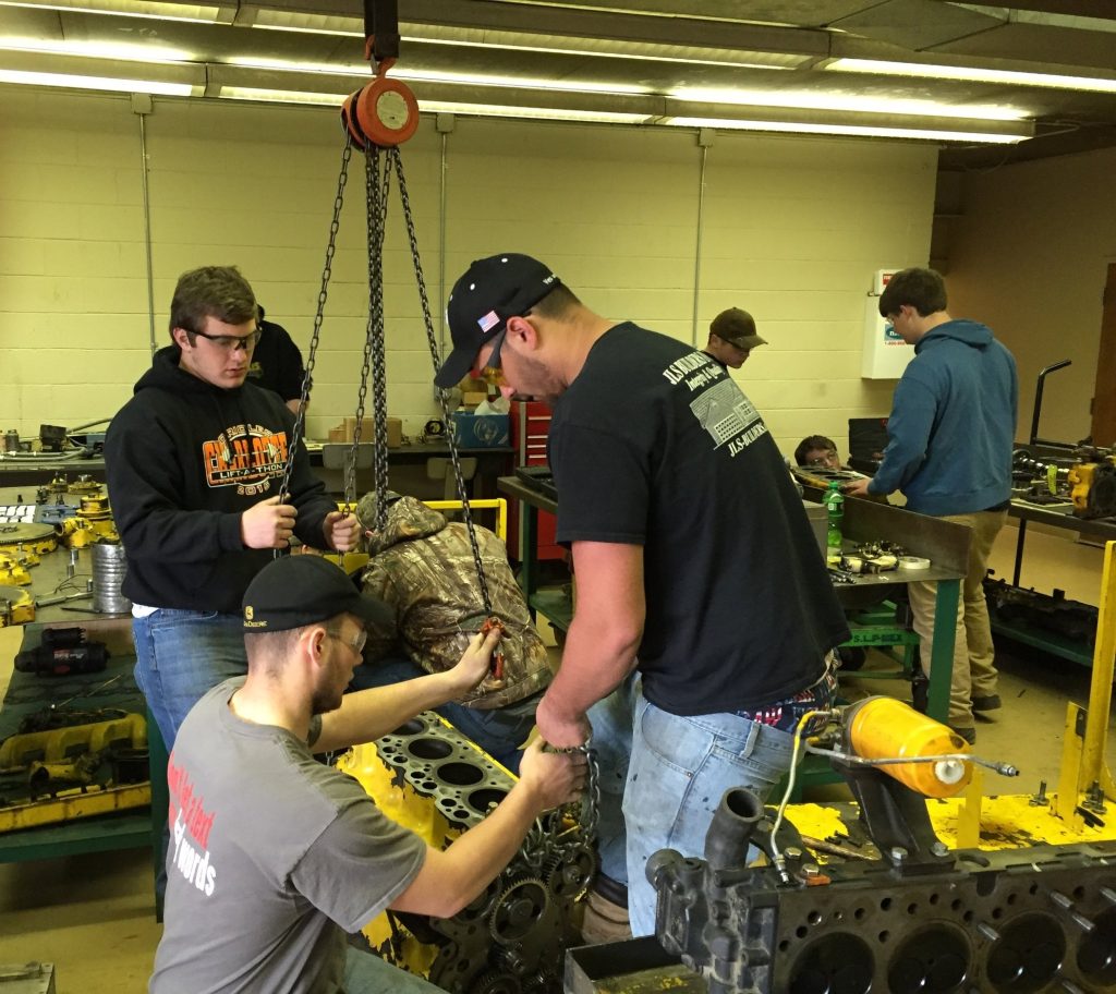 Students lifting engine block